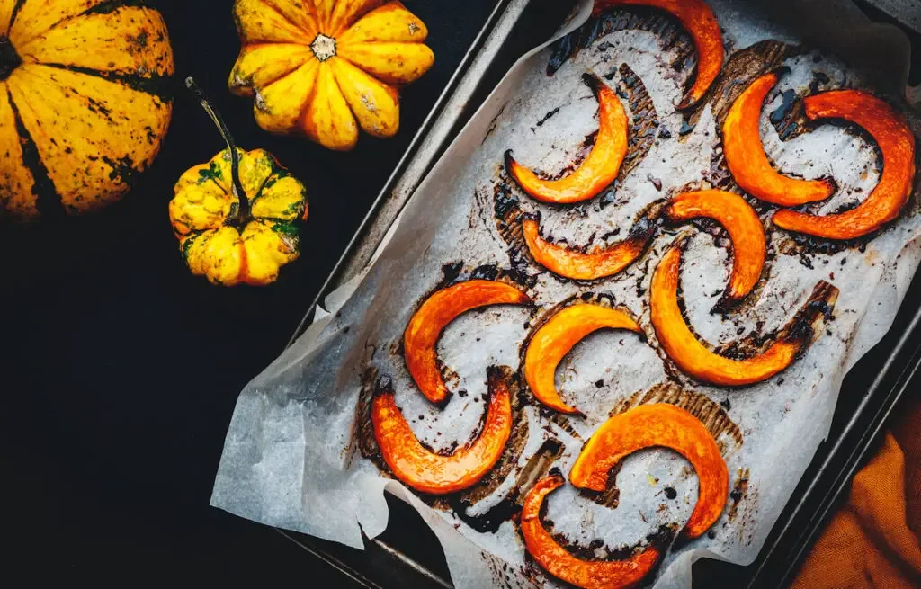 baked pumpkin slices on a parchment paper on a tray