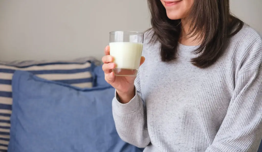 closeup of young woman holding a glass of milk