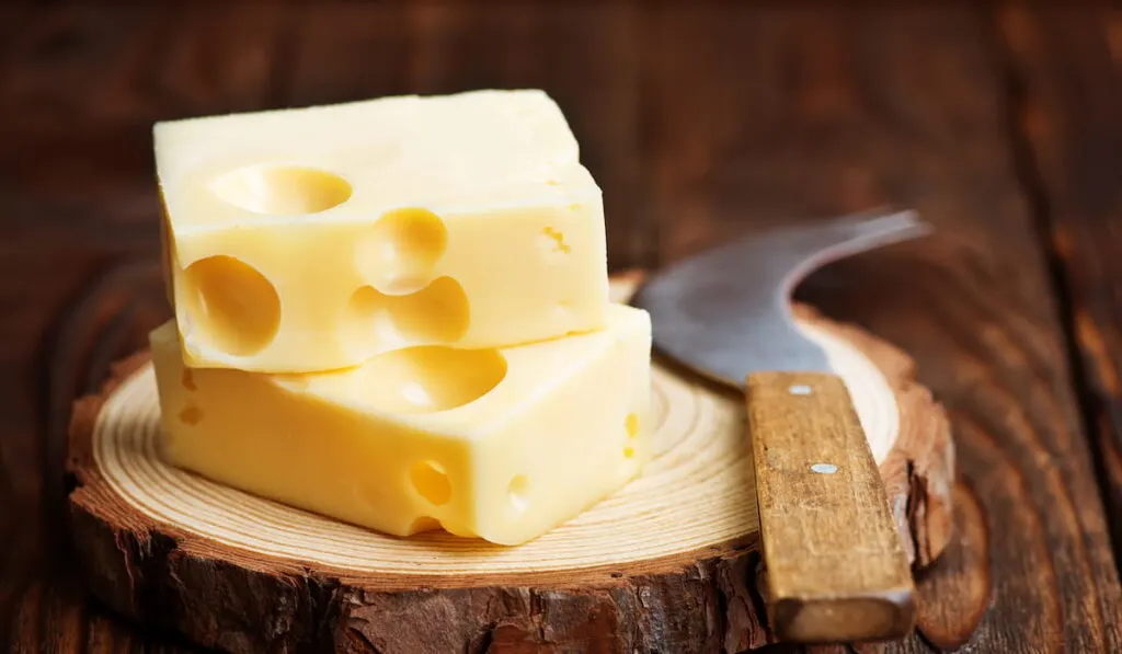 Cheese on a wooden board with a cheese knife