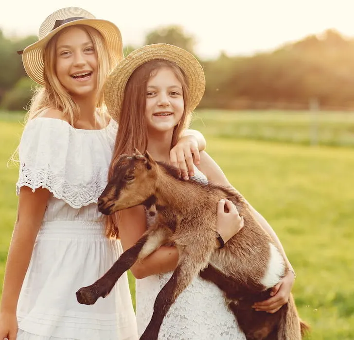 cute girls carrying a goat