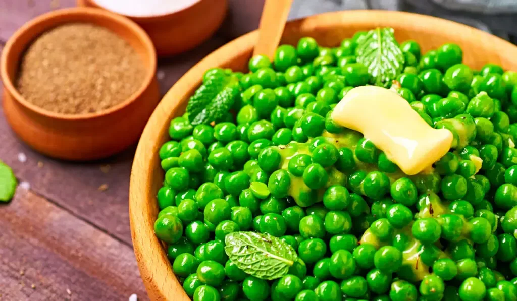 Buttered peas with mint in a wooden bowl