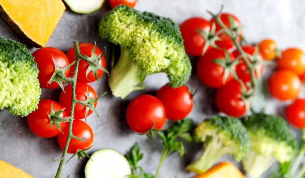 Fresh broccoli and cherry tomatoes on grey background